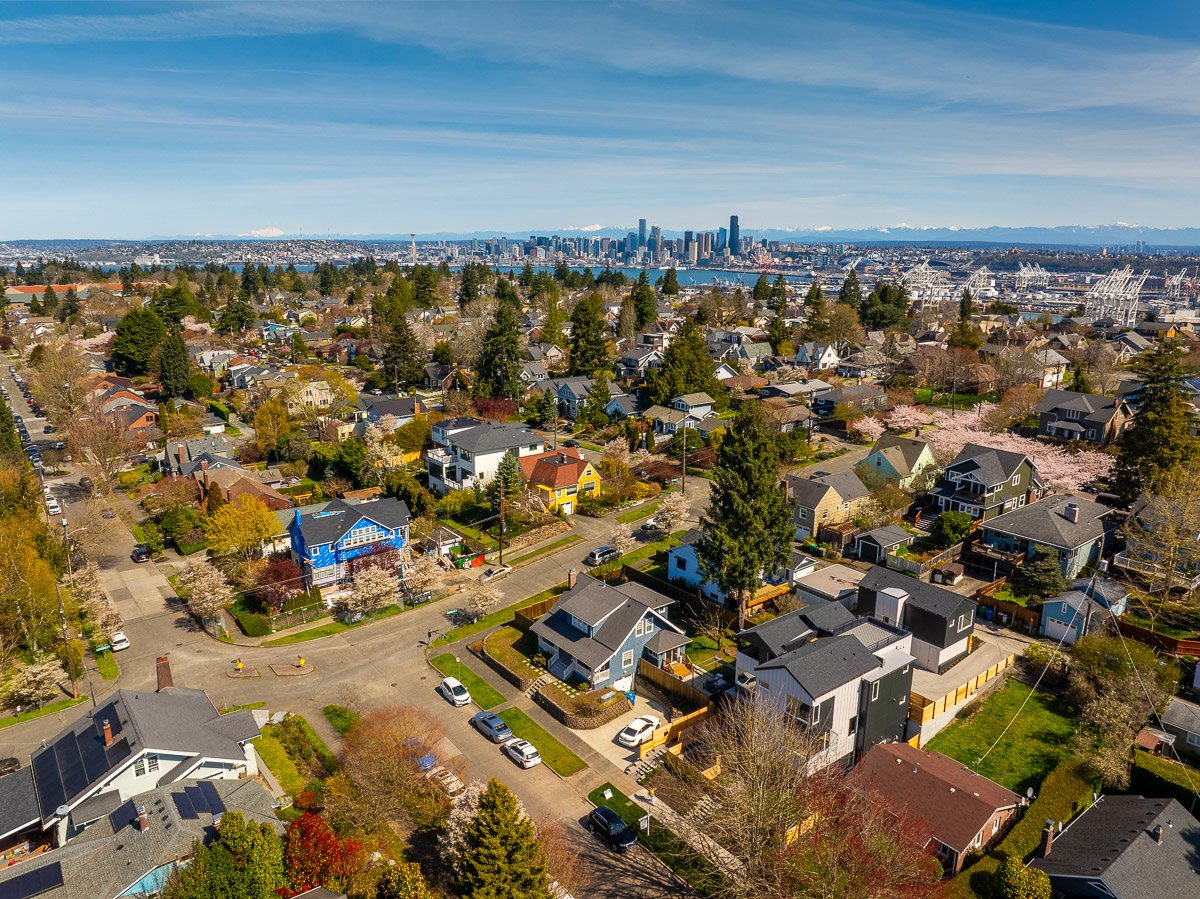 Aerial drone photo of a Seattle residential neighborhood with downtown skyline views, showcasing professional real estate photography for Realtors.