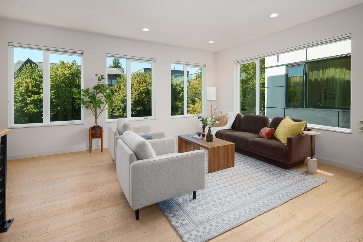rofessional real estate photography of a bright Seattle living room with modern furnishings, large windows, hardwood floors, and abundant natural light.