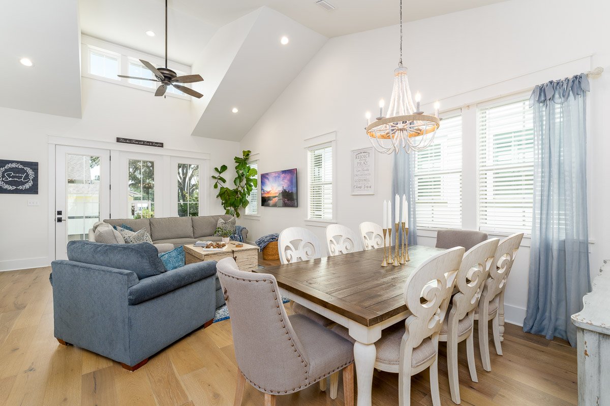 Professional real estate photography of a bright Seattle home interior with an open-concept dining and living area, vaulted ceilings, and abundant natural light.